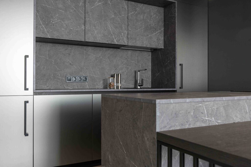 Gray quartz countertops in a modern kitchen with white cabinets and dark island base
